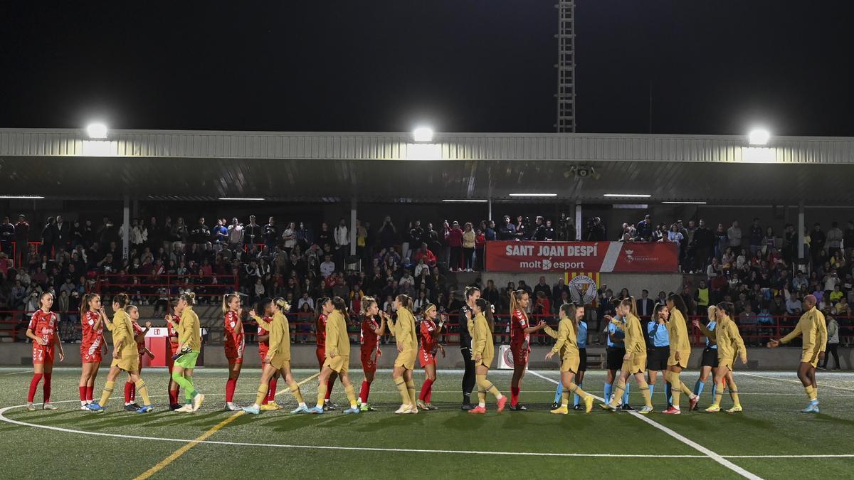 Las jugadoras de ambos equipos se saludan antes del inicio del partido aplazado de la primera jornada de la liga de fútbol femenino entre el Levante Las Planas y el FC Barcelona.