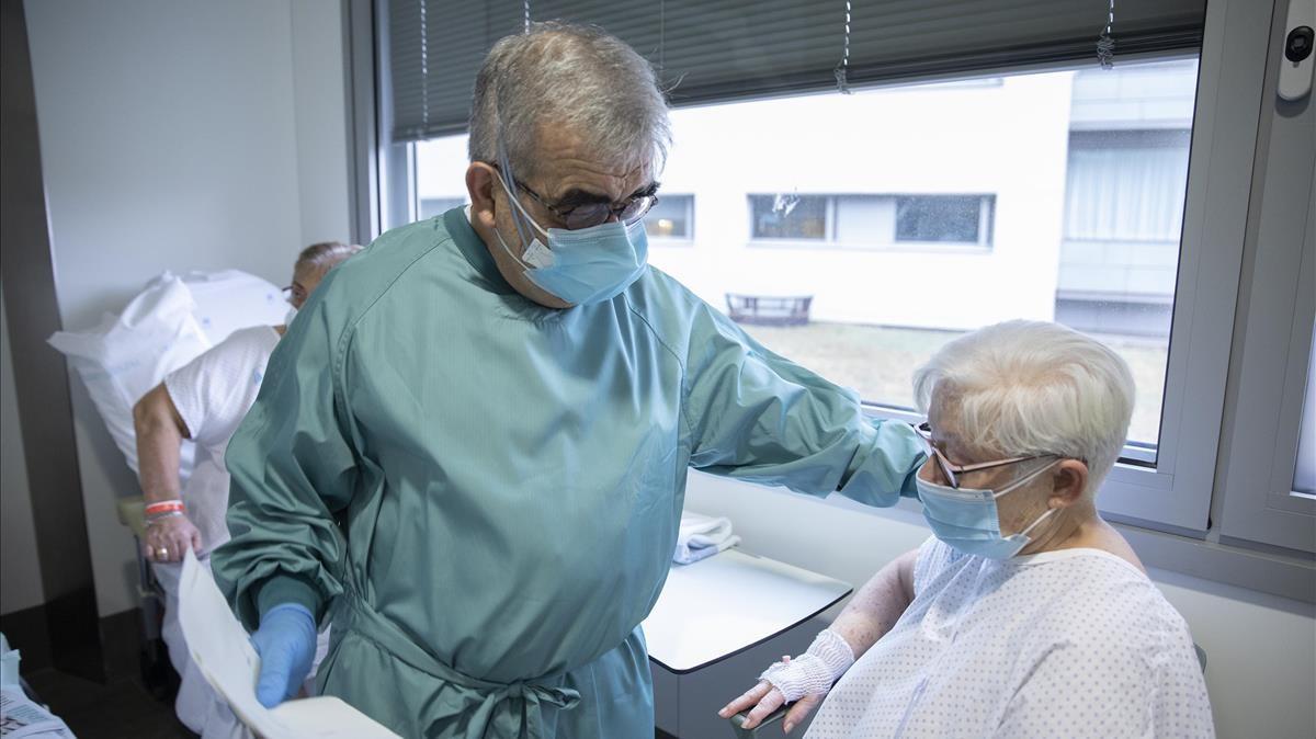 El doctor Pere Domingo, coordinador covid del Hospital de Sant Pau, atiende a la paciente Ángeles Navarro.