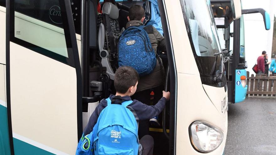 Alumnos subiendo a un autobús escolar en A Coruña. | Víctor Echave
