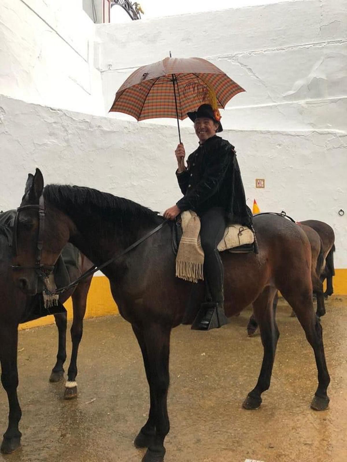 Cabazo, el alguacilillo, protegido bajo un paraguas.