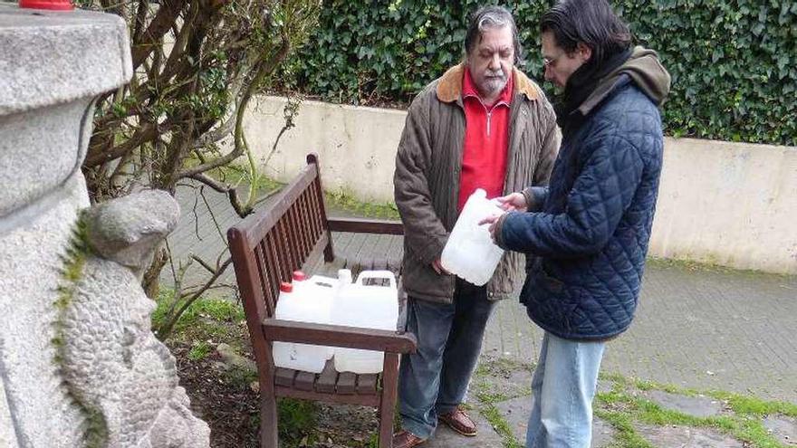 Vecinos de Santa Cruz, llenando garrafas en la fuente de Perillo.