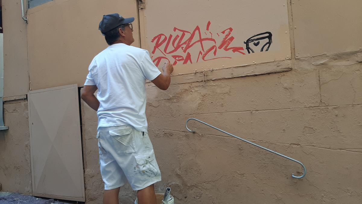 Un operario elimina una pintada en la Costa del Teatre.