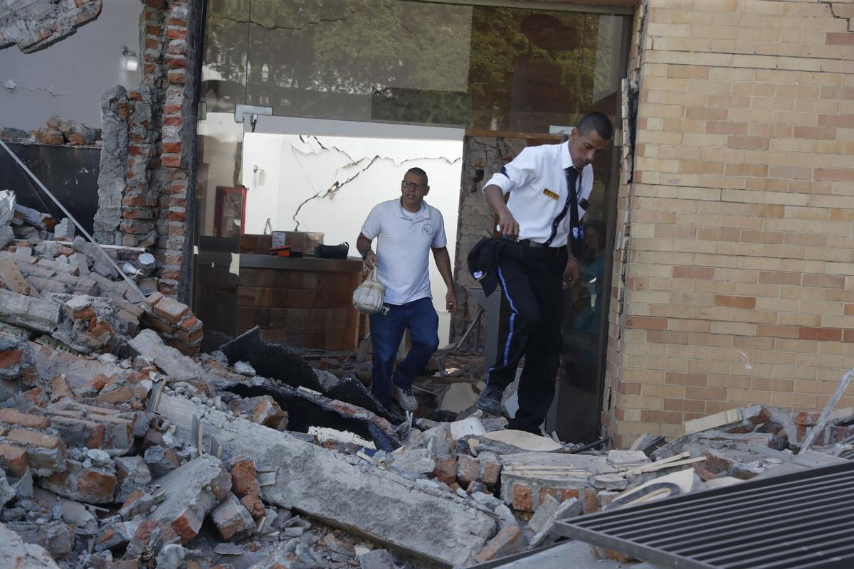Personas caminan sobre los escombros de un edificio colapsado este lunes, en Cali (Colombia). Personas caminan sobre los escombros de un edificio colapsado este lunes, en Cali (Colombia).