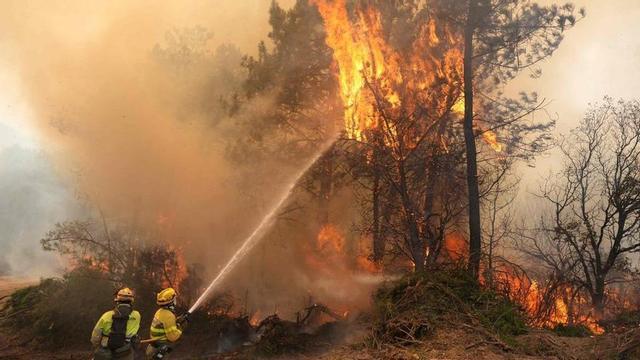 Els bombers lluiten contra les flames per intentar extingir l’incendi de la serra oest de Madrid.