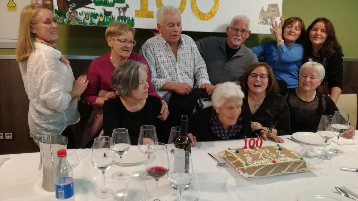 Isabel Domínguez sopla las velas de su centésimo cumpleaños, rodeada de sus hijos.