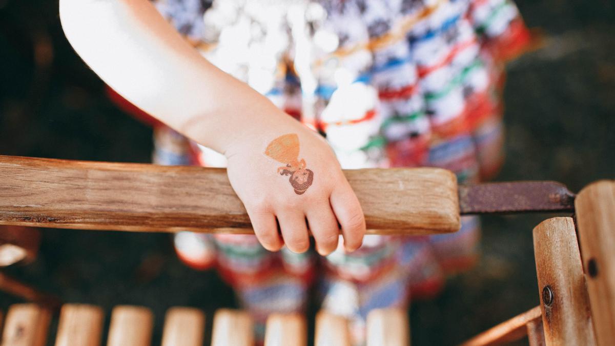 Imagen de recurso de una niña con una calcomanía en la mano.