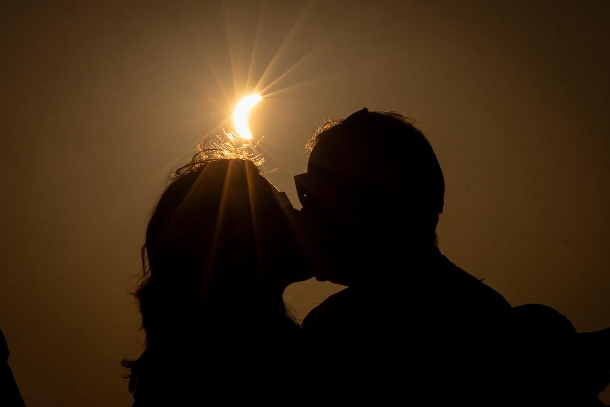 Una pareja se besa mientras la luna abraza al sol en Teruel.