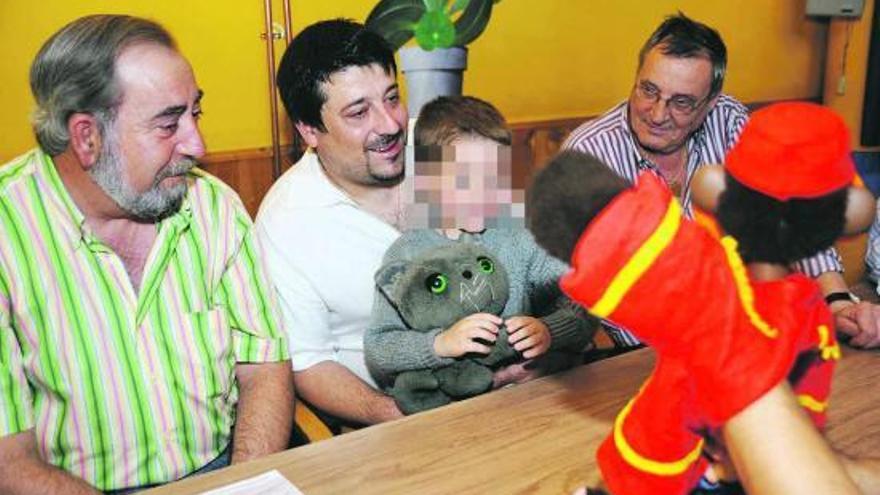 Jesús Manuel Ortiz y David Vázquez, con su hijo Javier en brazos, observan una marioneta en la presentación de la gala.