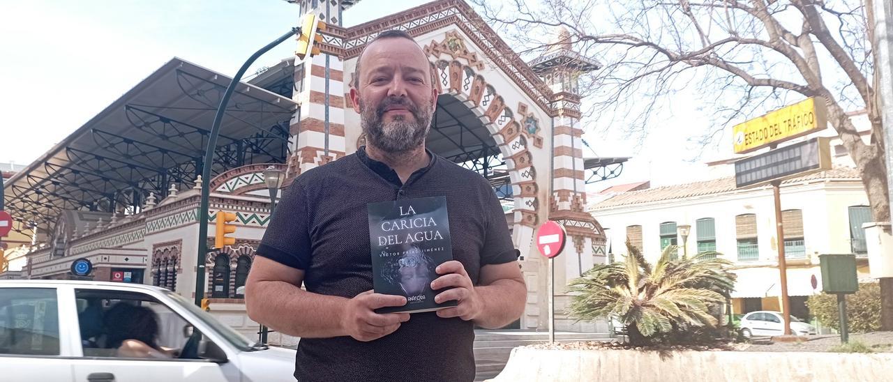 Víctor Frías, con su nueva novela, delante del mercado del Molinillo.