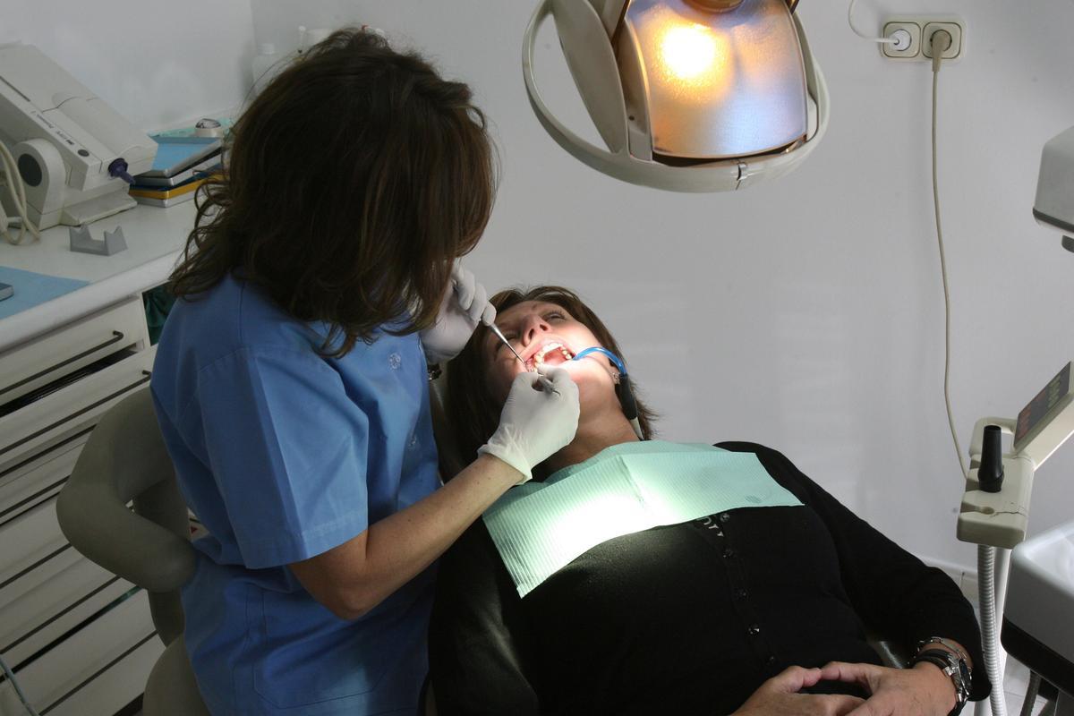 Una dentista atiende a un paciente.