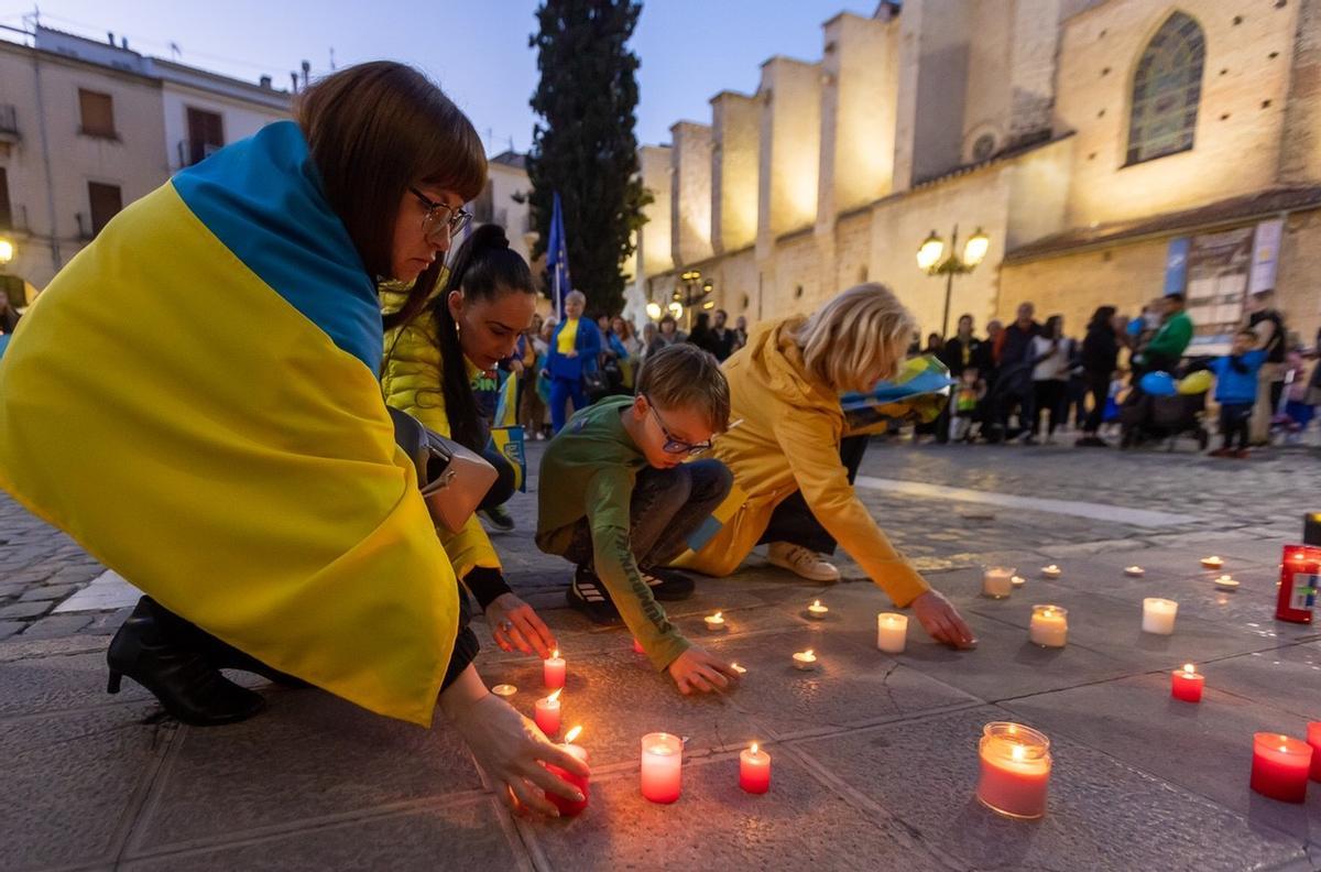 Niños depositan velas en la plaza Major.