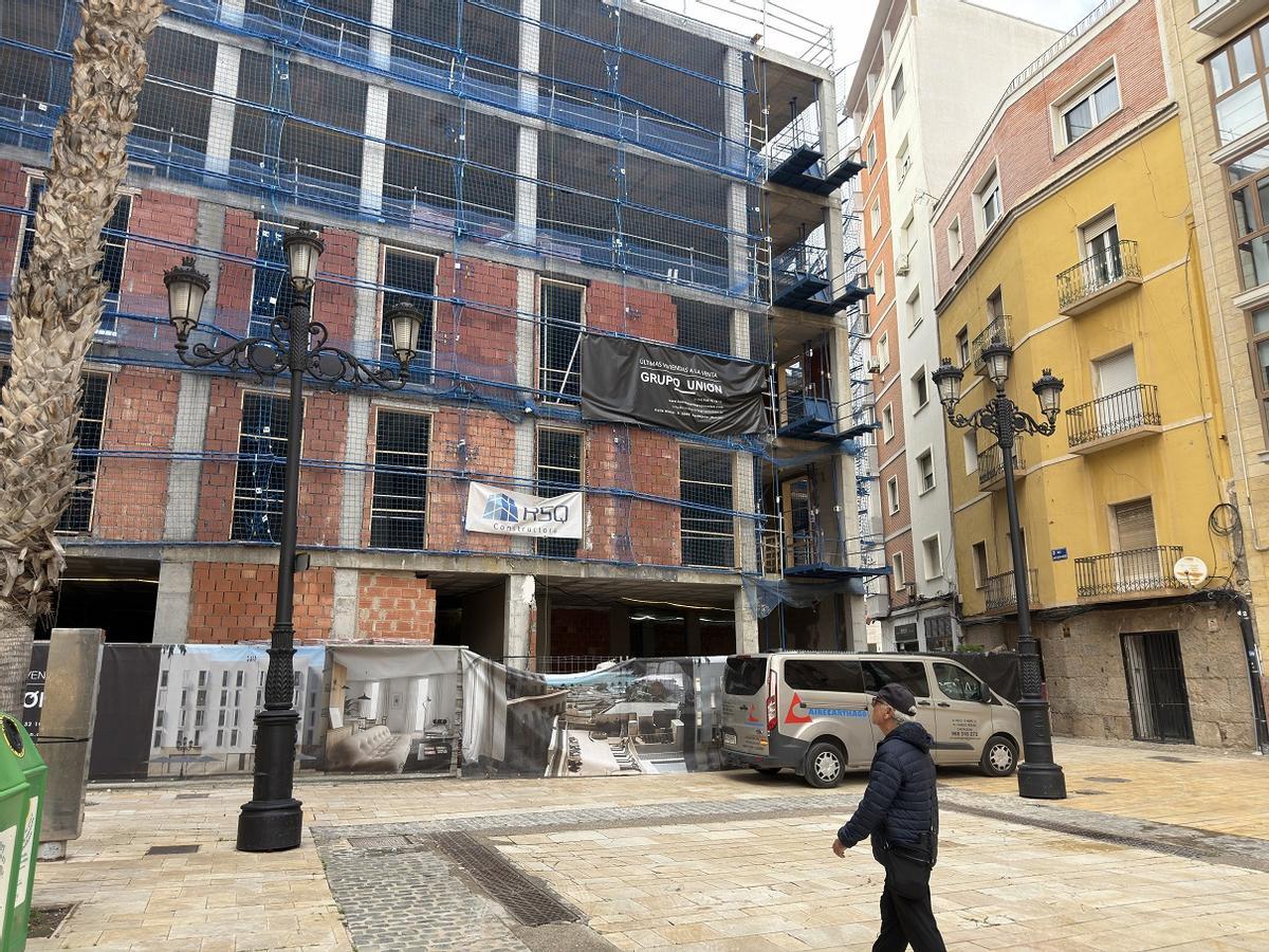 Un vecino de Cartagena pasa frente a un bloque de viviendas en construcción, este viernes.