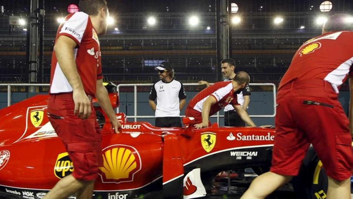 Alonso bromea con mecánicos de Ferrari, el pasado mes de septiembre en Singapur.