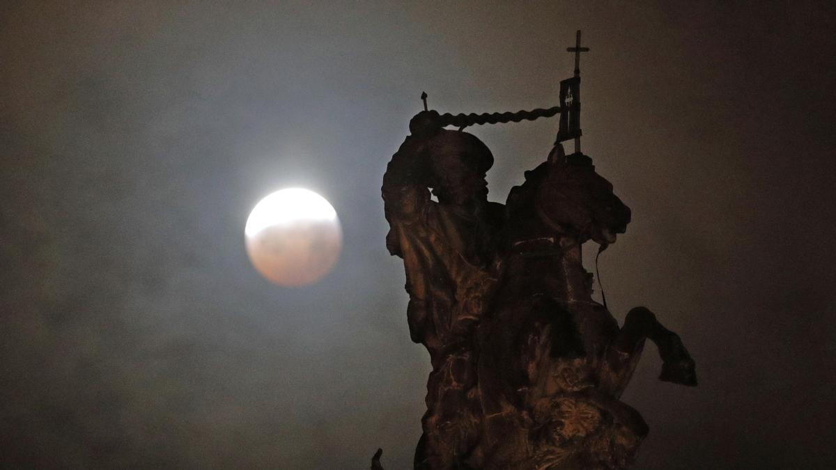 La luna llena durante la fase final del eclipse total, sobre una figura ecuestre del Apóstol Santiago, en 2019.