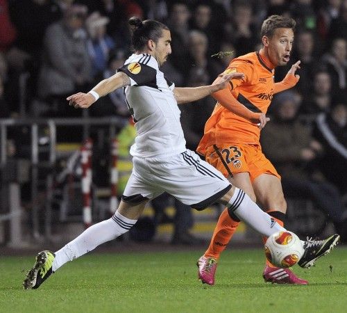 El jugador del Valencia, Sergio Canales pugna con un jugador del Swansea.
