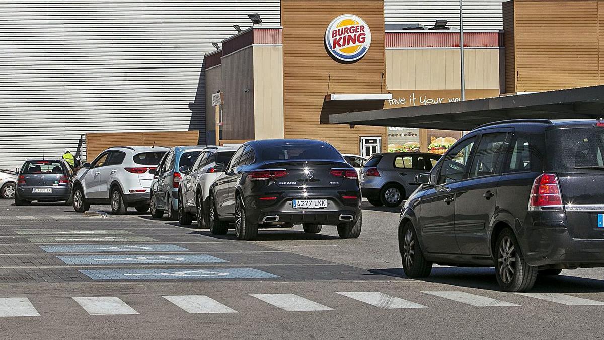 Vehículos hacen cola para recoger sus pedidos en un local de comida rápida. | HÉCTOR FUENTES