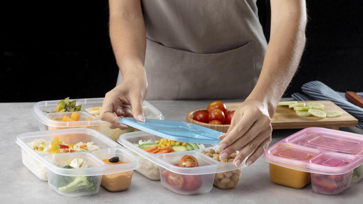 Una mujer haciendo 'batch cooking', guardando la comida en distintos táperes.