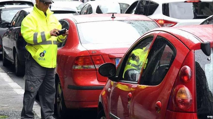 Un agente de la ORA controla el pago de un vehículo.