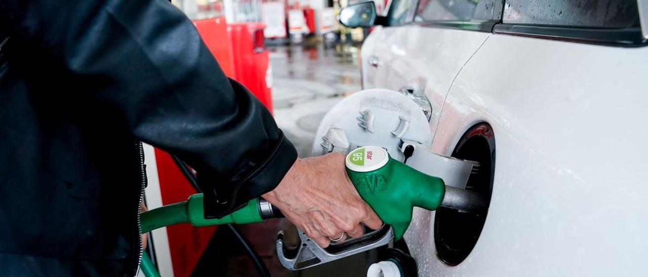 Una mujer reposta en una gasolinera