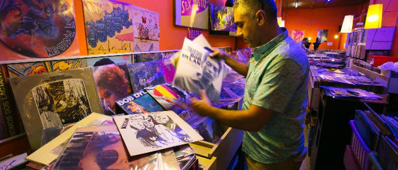 Pablo Gallego repasa la colección de vinilos de Bob Dylan que tiene a la venta en su tienda 33 revoluciones, en la calle Tomás Morales.