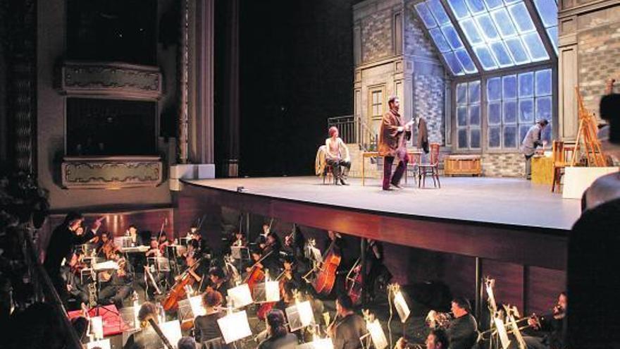 Arriba, la orquesta y la escenografía con la que arrancó «La Bohème»; a la derecha, público del Jovellanos.