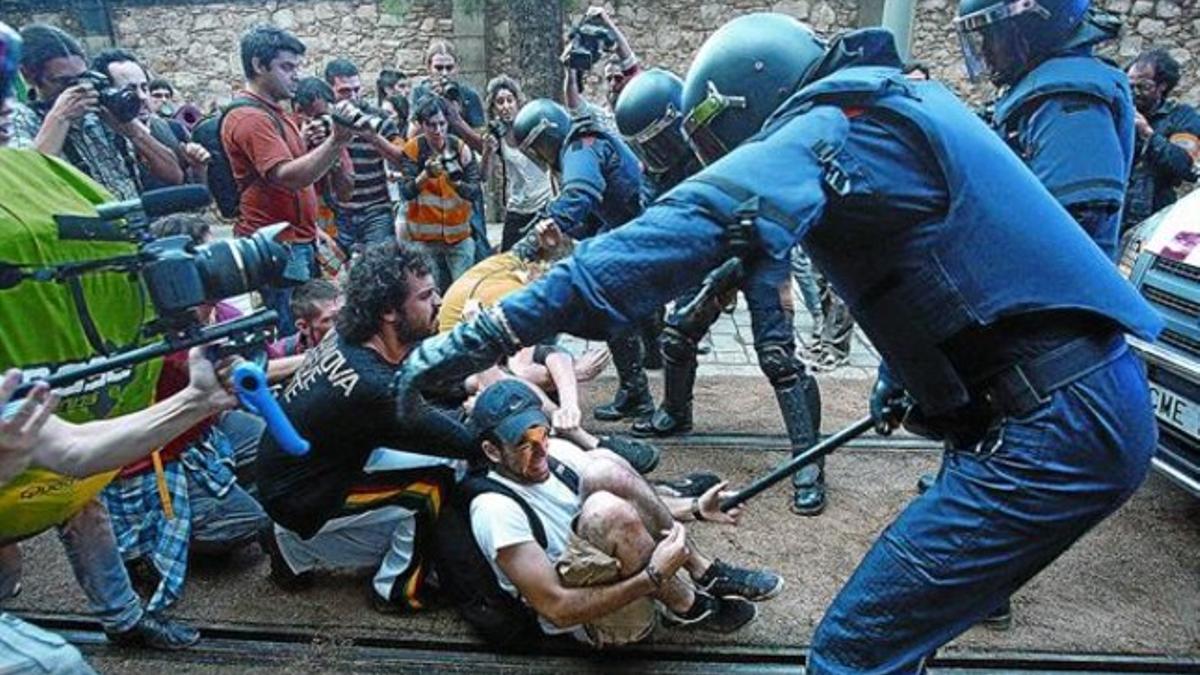 Unos mossos desalojan a participantes en la sentada en la calle de Wellington, ayer por la mañana.