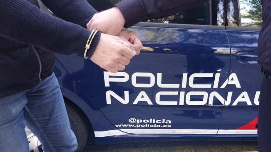 Un detenido sale de un vehículo de la Policía Nacional.