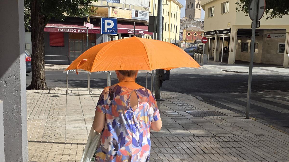BADAUJOZ. OLA DE CALOR, UNA SEÑORA SE PROTE DEL SOL CON UNA SOMBRILLA O PARAGUAS,