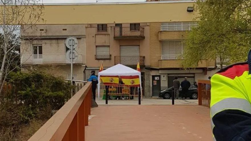 La carpa deVox al fons i en primer terme un policia