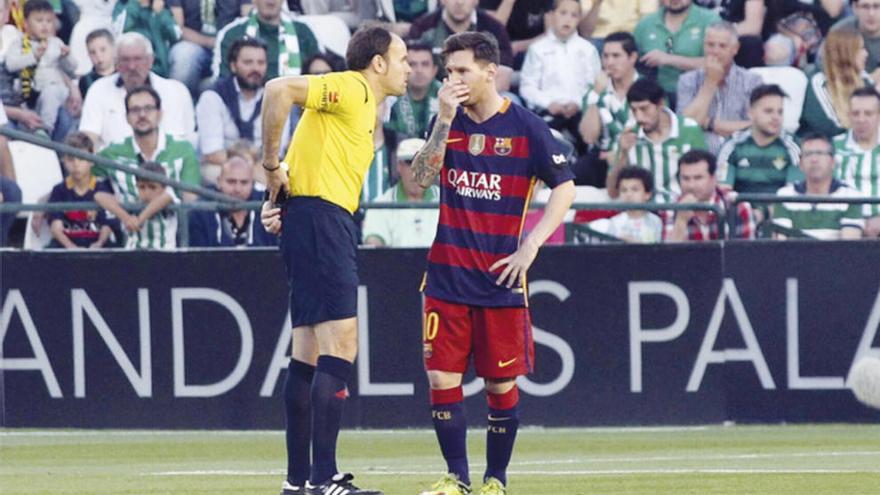 Messi discute una decisión con el árbitro de un partido.