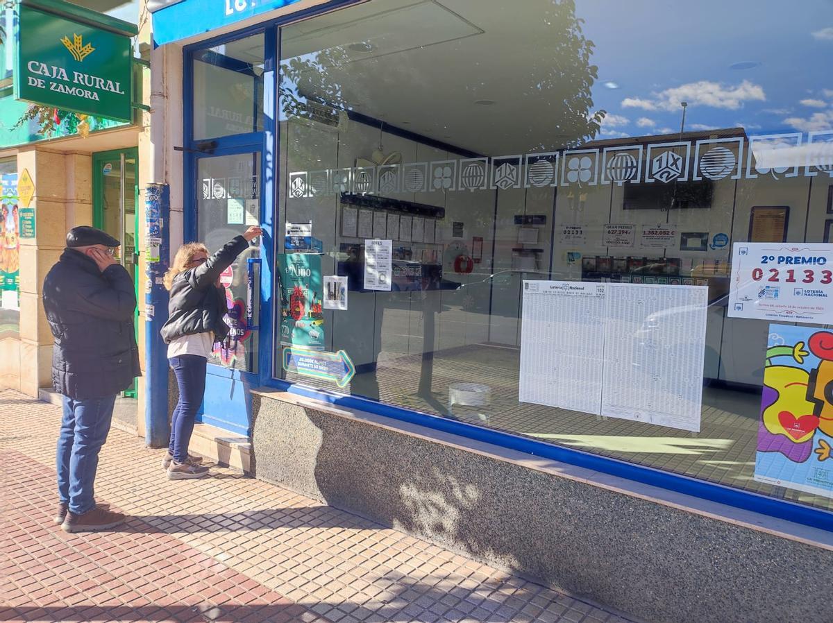 Los propietarios de la administración de Benavente que ha vendido el primer premio del Niño abren el local.