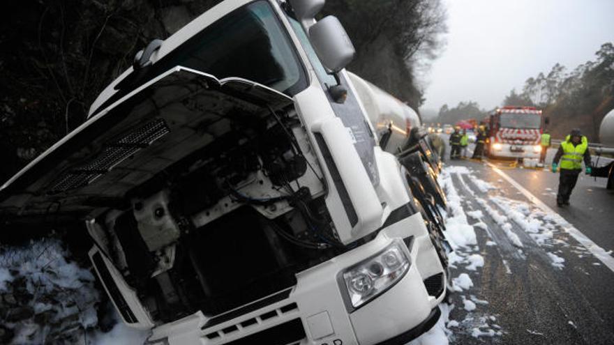 El camión accidentado que provocó el derrame, ayer, en la cuneta de la autopista.  // Juan Varela