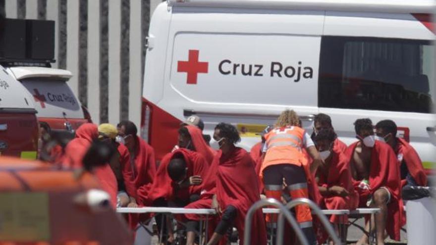 Cruz Roja asiste, ayer, a un grupo de migrantes en el muelle de Puerto Naos, en Lanzarote.