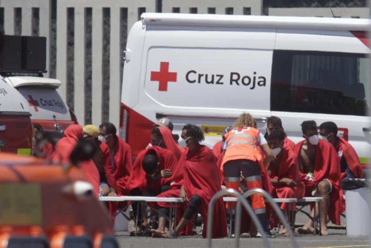 Cruz Roja asiste, ayer, a un grupo de migrantes en el muelle de Puerto Naos, en Lanzarote. | | ADRIEL PERDOMO/EFE