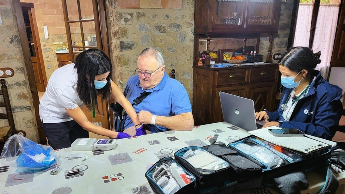 Dues professionals de la Fundació Salut Empordà atenent un pacient a casa seva.