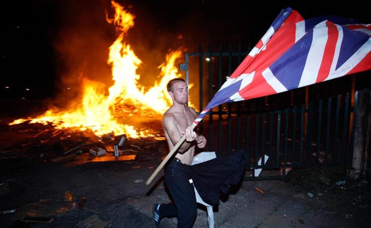 Un manifestant unionista fa onejar una bandera britànica durant els disturbis d’ahir a la nit a Belfast, Irlanda del Nord.