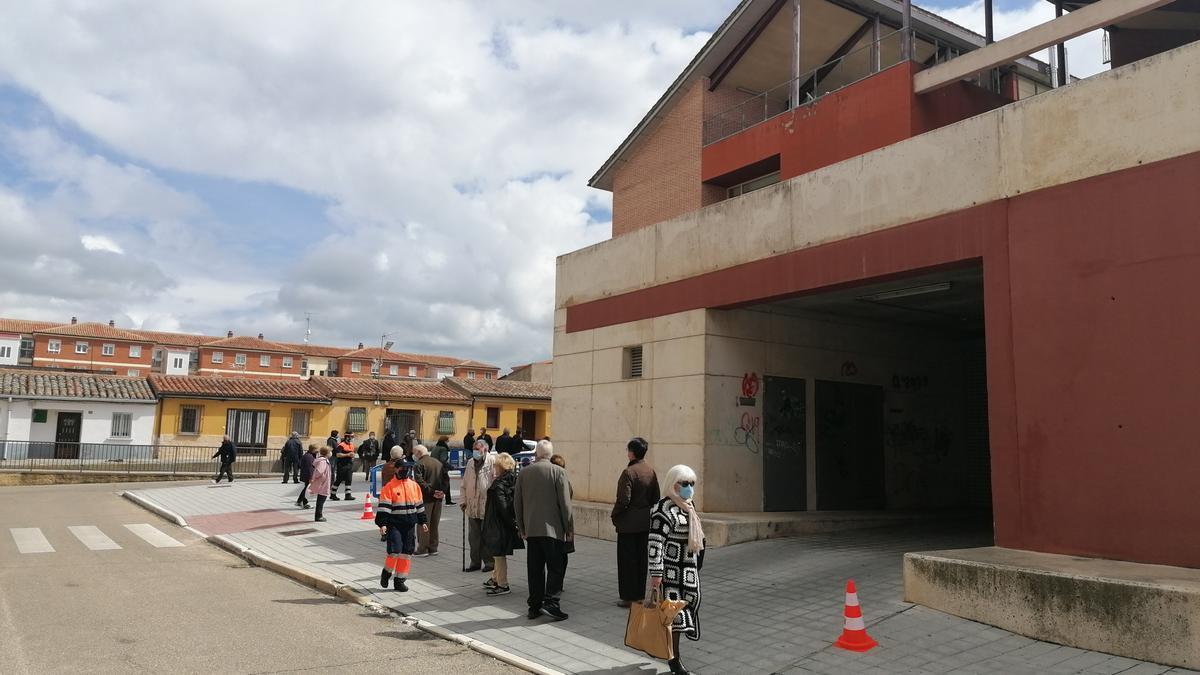 Vecinos guardan cola para esperar su turno de vacunación en el consultorio médico