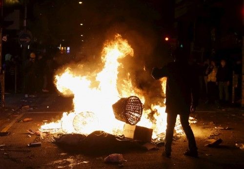 A protester throws a basket into a fire during a clash with riot police at Mongkok district in Hong Kong