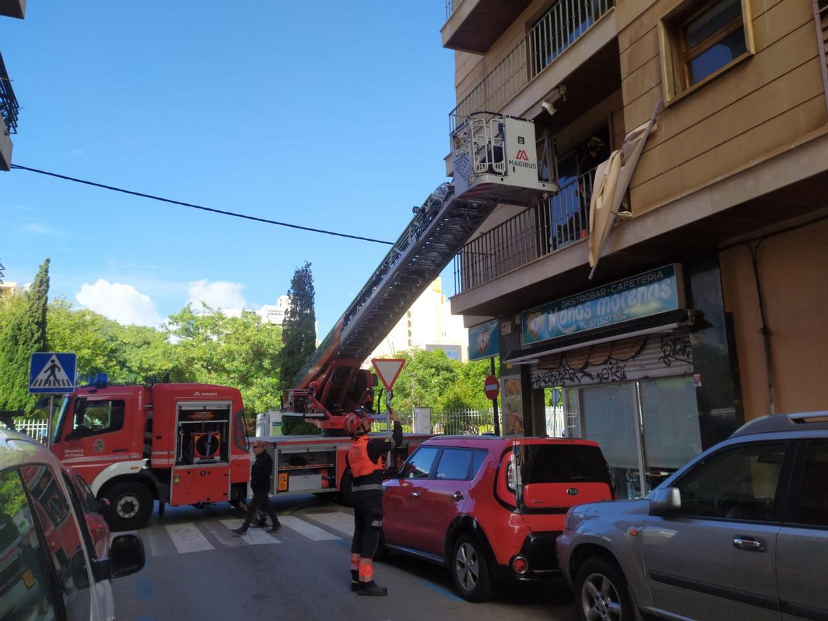 Los bomberos aseguran un toldo en un primer piso de la calle Joaquim Maria Bover, en Palma