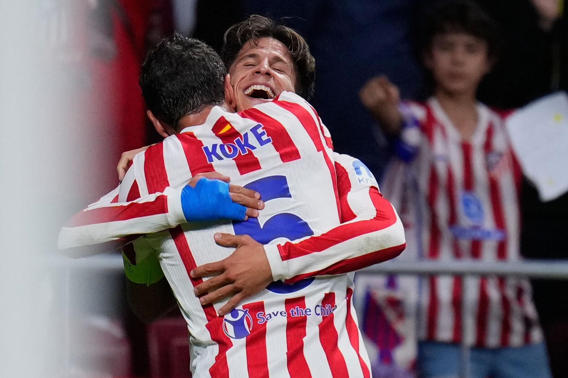 Atletico Madrid's Giuliano Simeone celebrates with team mate Koke after scoring his side's fourth goal during the Champions League opening phase soccer match between Atletico Madrid and Eintracht Frankfurt at the Metropolitano stadium in Madrid, Spain, Tuesday, Sept. 30, 2025. (AP Photo/Manu Fernandez)