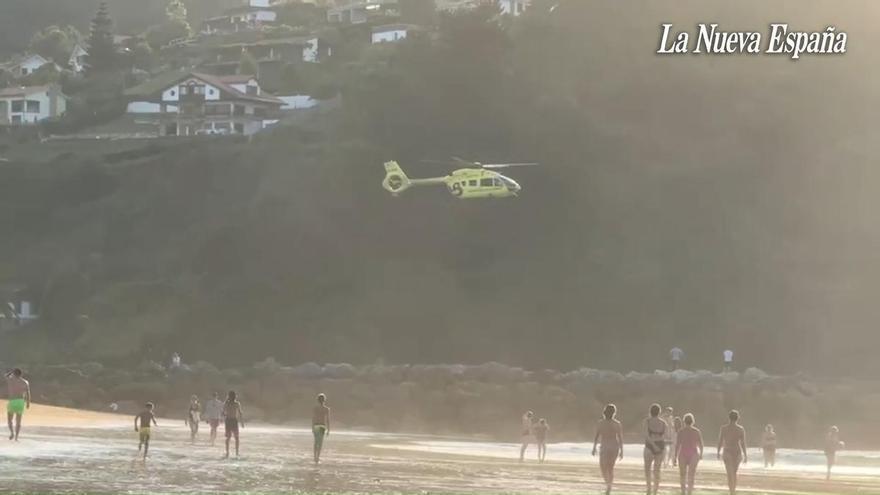 Alarma en Rodiles: aterriza en el arenal el helicóptero de Emergencias por un hombre arrastrado por la corriente
