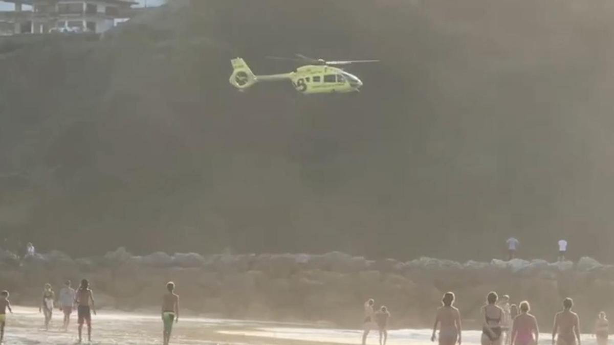 Alarma en Rodiles: aterriza en el arenal el helicóptero de Emergencias por un hombre arrastrado por la corriente