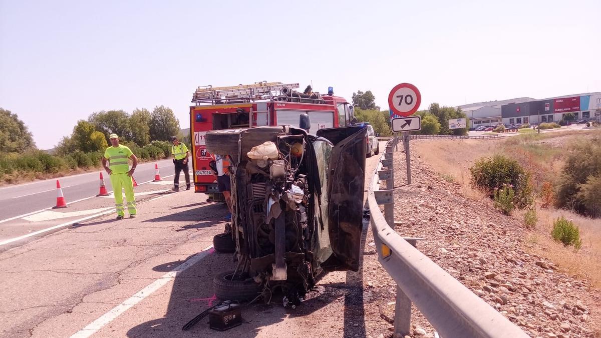 Estado del vehículo tras el accidente, con un vehículo de bomberos y operarios al fondo.