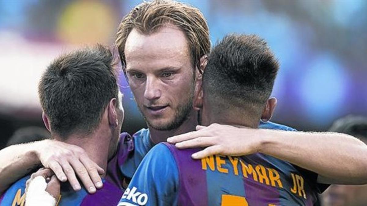 Messi y Neymar se abrazan a Rakitic tras el segundo tanto del brasileño, el tercero del Barça.