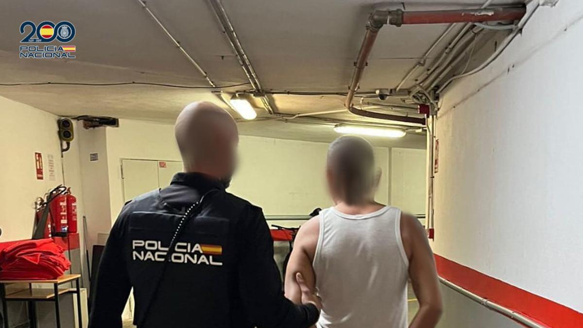 Un agente de la Policía Nacional llevan detenido al narco colombiano fugitivo.