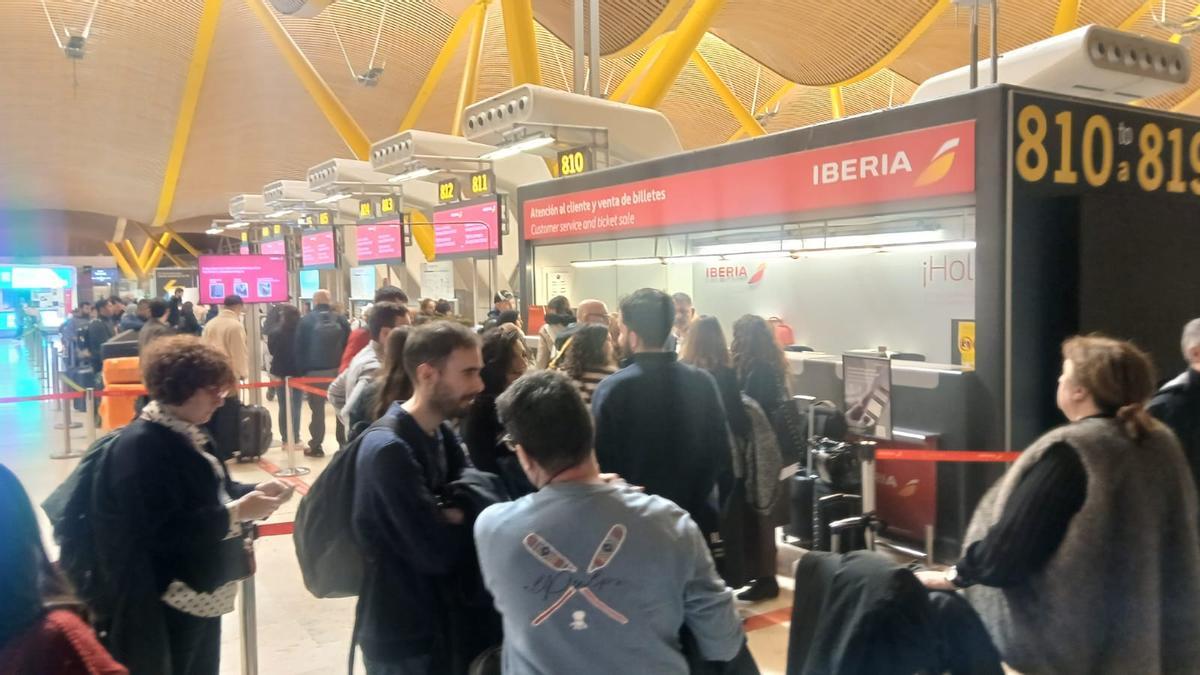 Pasajeros con destino Vigo ante la oficina de Iberia.