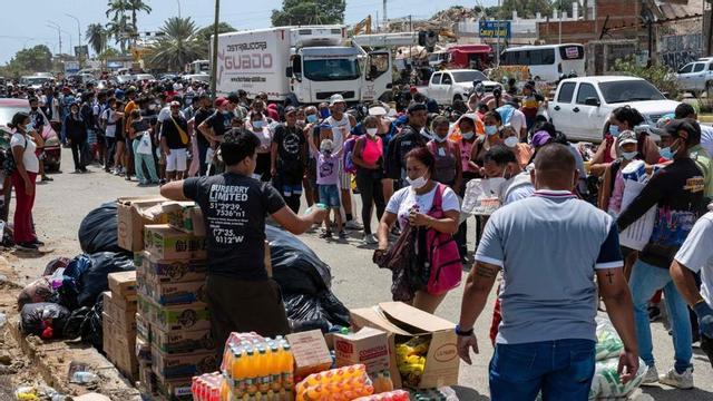 Cua en un punt de repartiment de menjar i beguda a Carabadella, a l’estat de La Guaira.   | MIGUEL MEDINA / FRANCE PRESSE