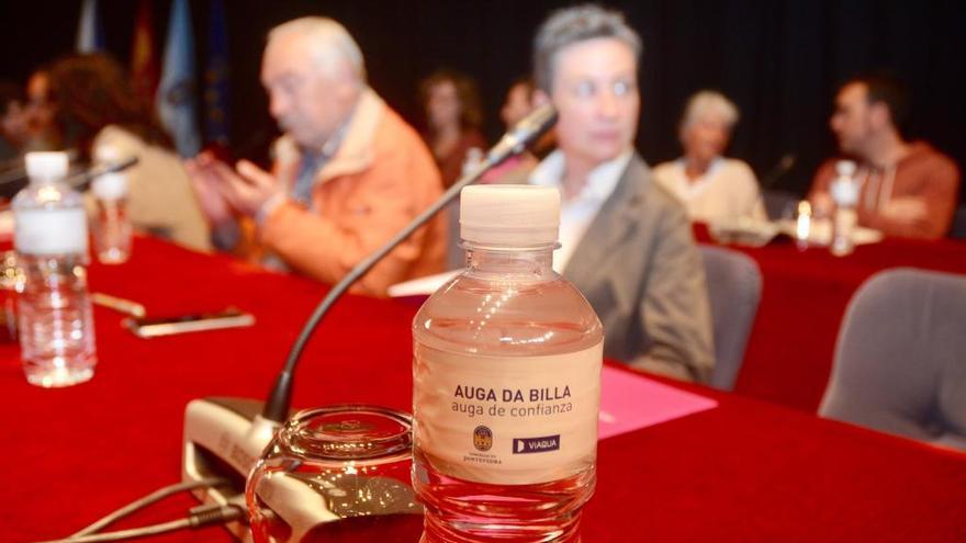 Las mesas de los concejales del gobierno local con las botellas de &quot;auga da billa&quot;