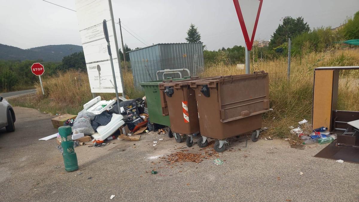 Residuos, trastos y enseres junto a unos contenedores en una zona diseminada de Bocairent.