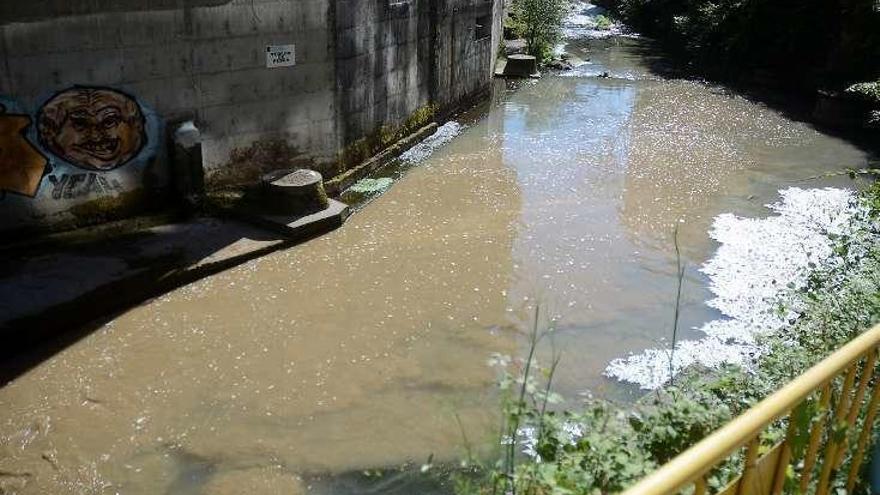 El río de color marrón, a su paso por Campolongo.  // R. Vázquez